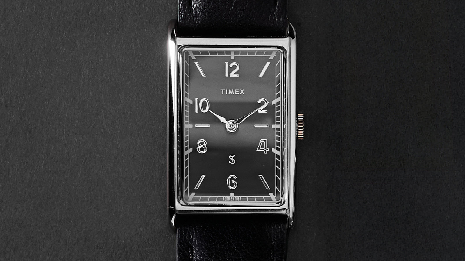 Close-up of the Timex x Todd Snyder 1976 Lexington watch face featuring a black dial, Arabic numerals, and rectangular case.