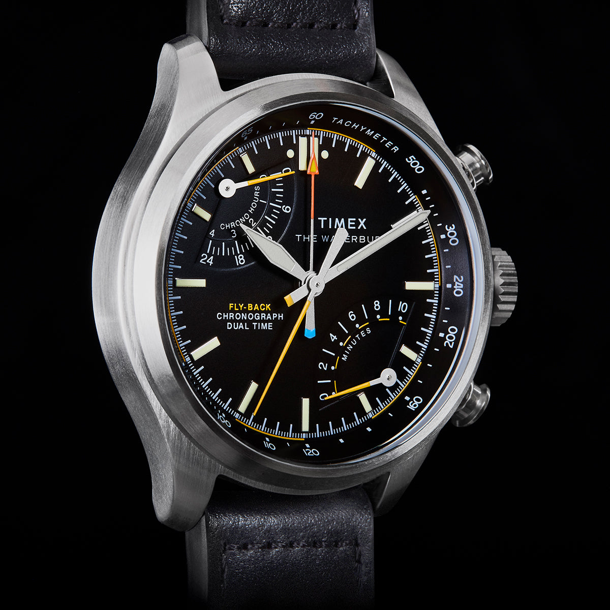 Close-up of Timex Waterbury Ace Fly-Back Chronograph black dial showing subdials, tachymeter scale, and luminous hands