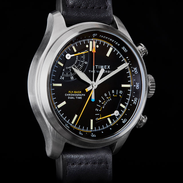 Close-up of Timex Waterbury Ace Fly-Back Chronograph black dial showing subdials, tachymeter scale, and luminous hands