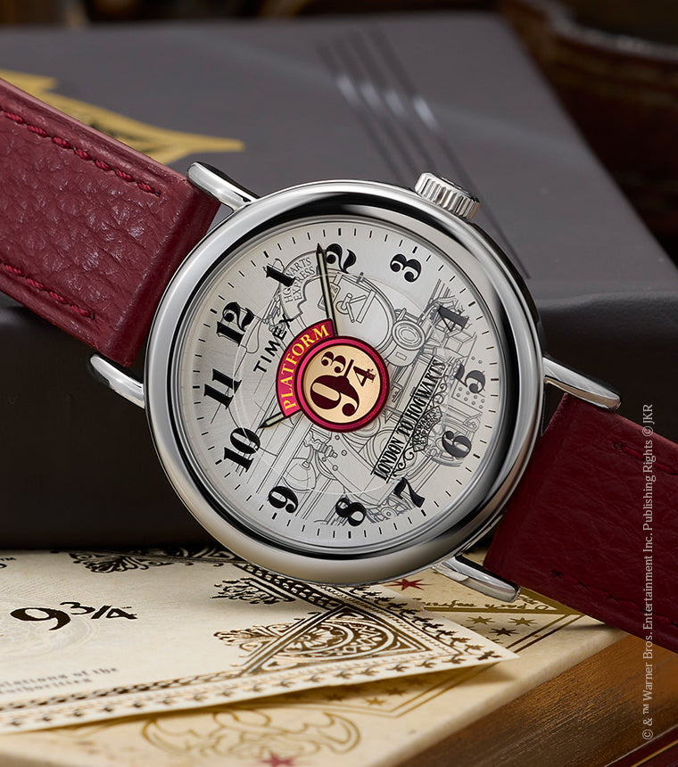 Harry Potter x Timex Weekender Platform 9¾ watch with silver-tone case and red leather strap displayed on Hogwarts books and ticket.