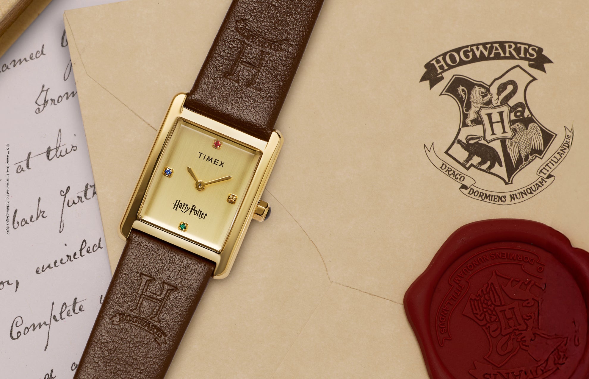 Harry Potter x Timex Hailey Hogwarts watch with gold-tone rectangular case displayed on a Hogwarts letter with red wax seal.