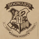 Close-up of Hogwarts crest with house animals and motto Draco Dormiens Nunquam Titillandus.