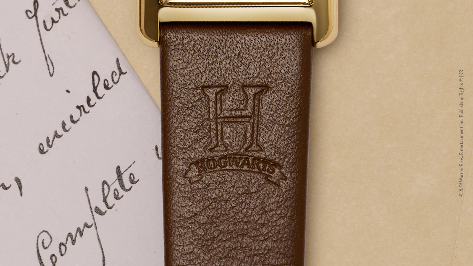 Close-up of brown leather strap embossed with Hogwarts “H” crest on Harry Potter x Timex Hailey watch.