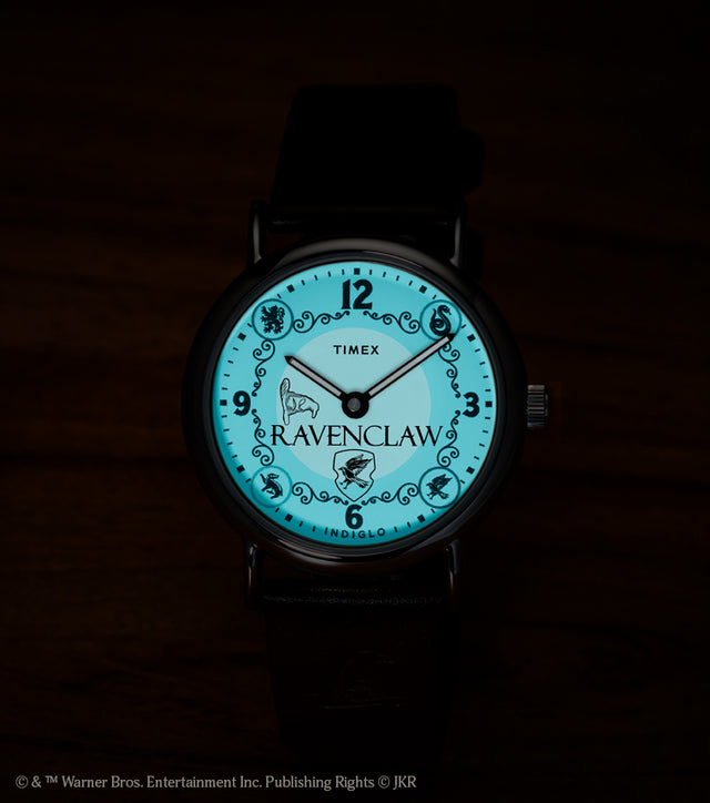 Harry Potter x Timex Weekender Ravenclaw watch illuminated in blue INDIGLO mode showing Ravenclaw name and house crest.