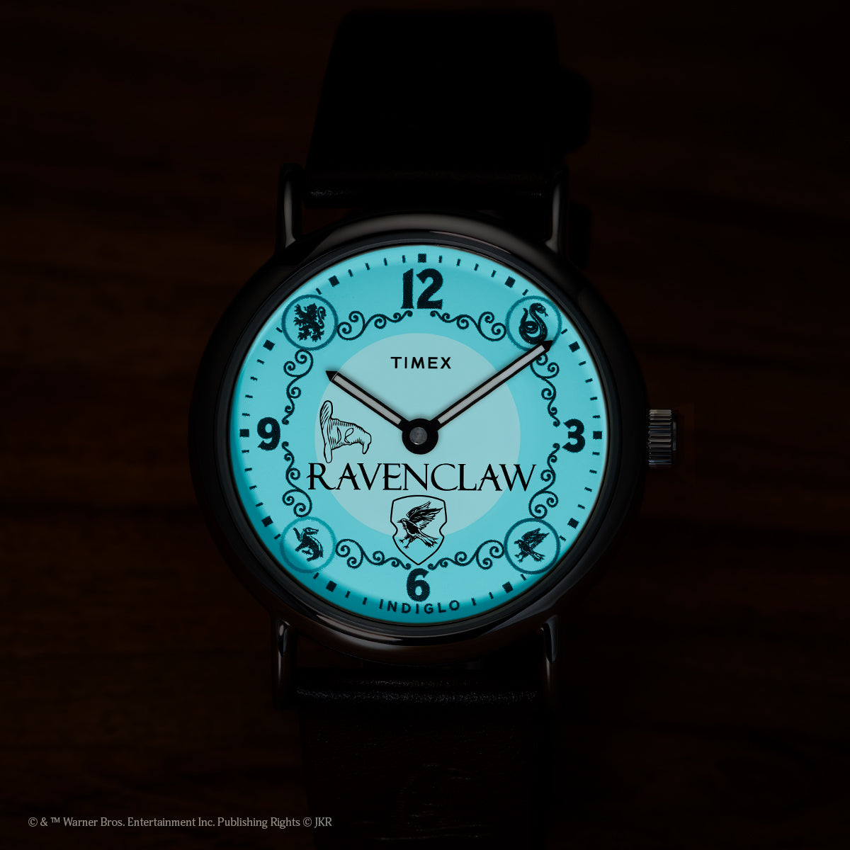 Harry Potter x Timex Weekender Ravenclaw watch illuminated in blue INDIGLO mode showing Ravenclaw name and house crest.