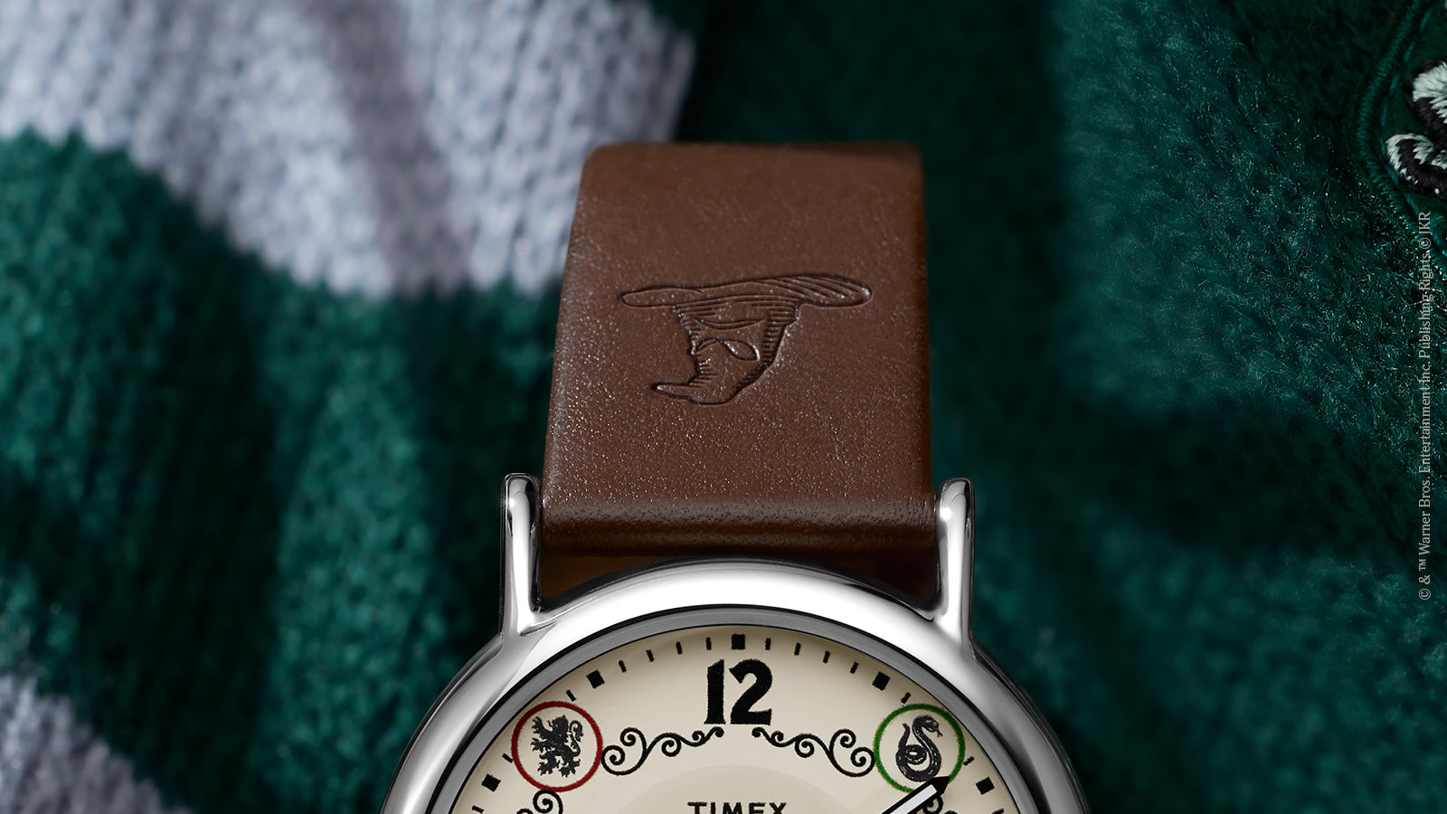 Close-up of brown leather strap embossed with Sorting Hat on Harry Potter x Timex Slytherin watch.