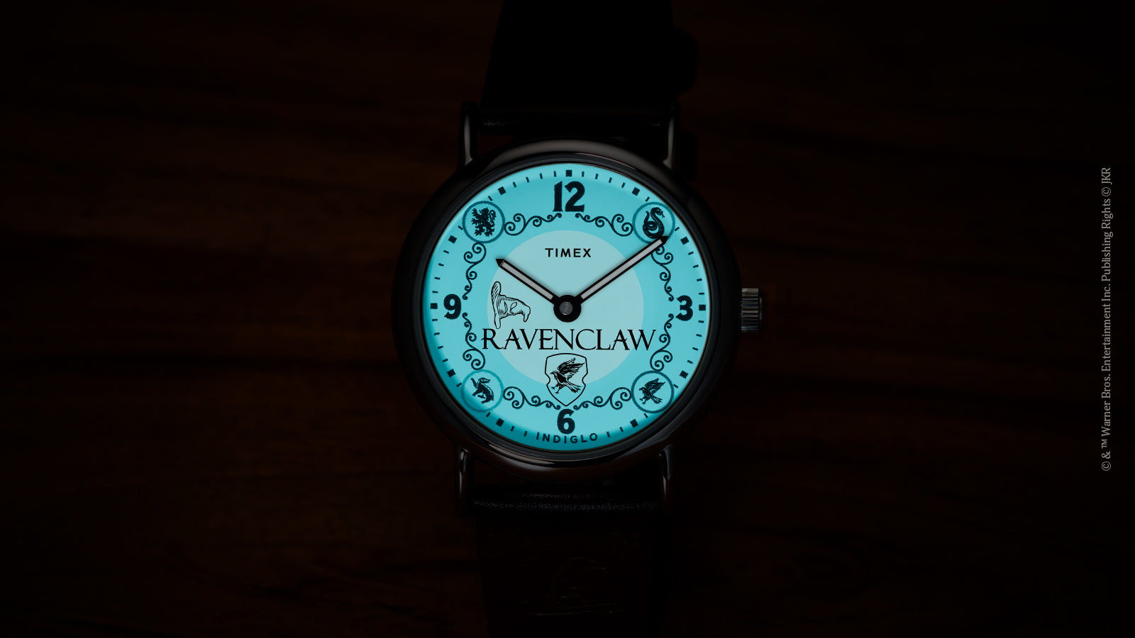 Harry Potter x Timex Weekender Ravenclaw watch illuminated in blue INDIGLO mode showing Ravenclaw name and house crest.