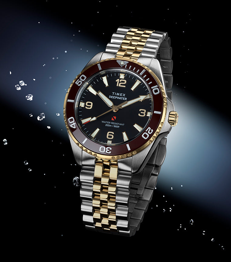 Timex Deepwater Arctic two-tone stainless steel and gold watch with burgundy bezel in water splash