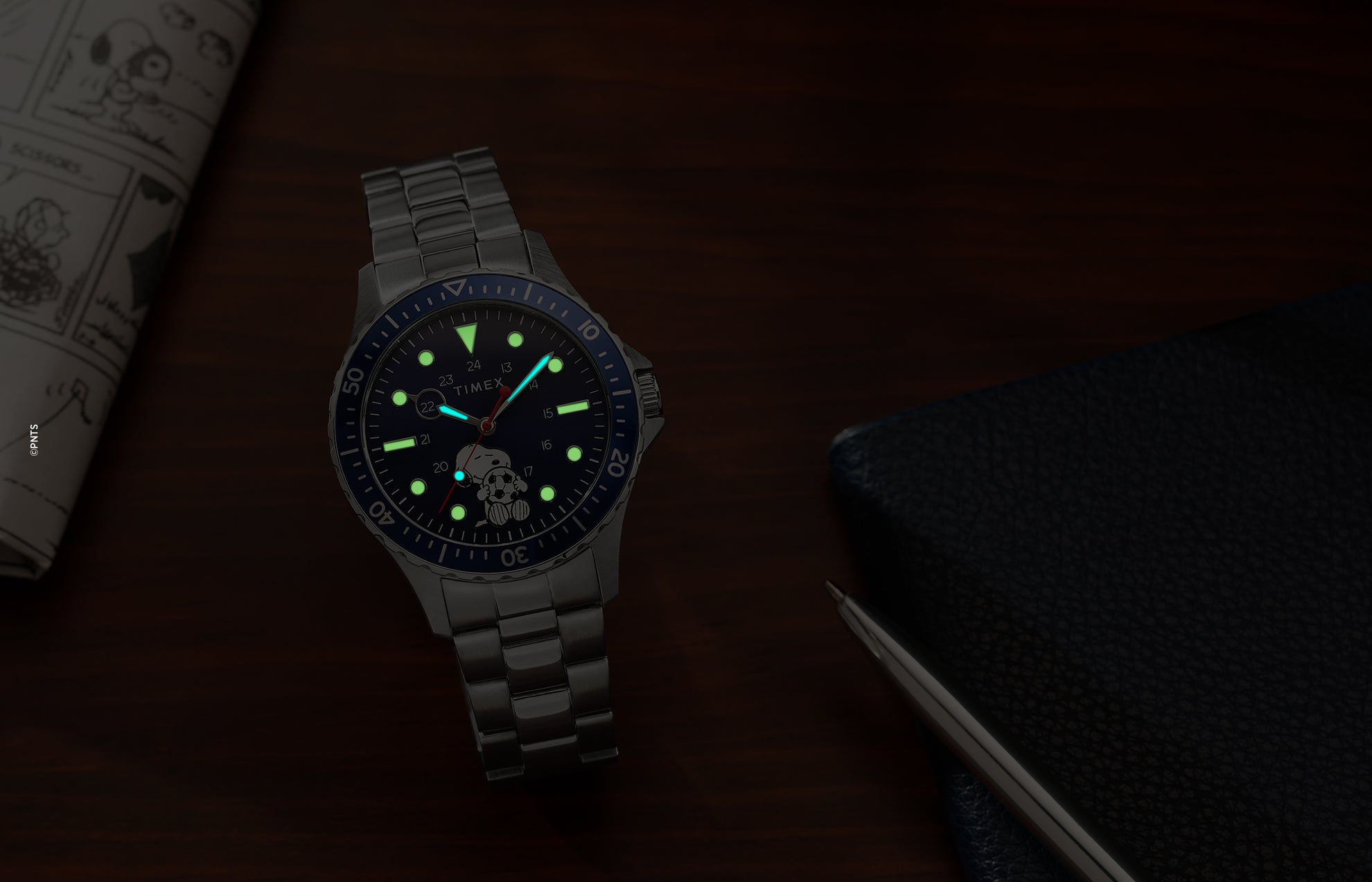 Timex Navi Snoopy soccer watch glowing in the dark with luminous markers and hands on blue dial
