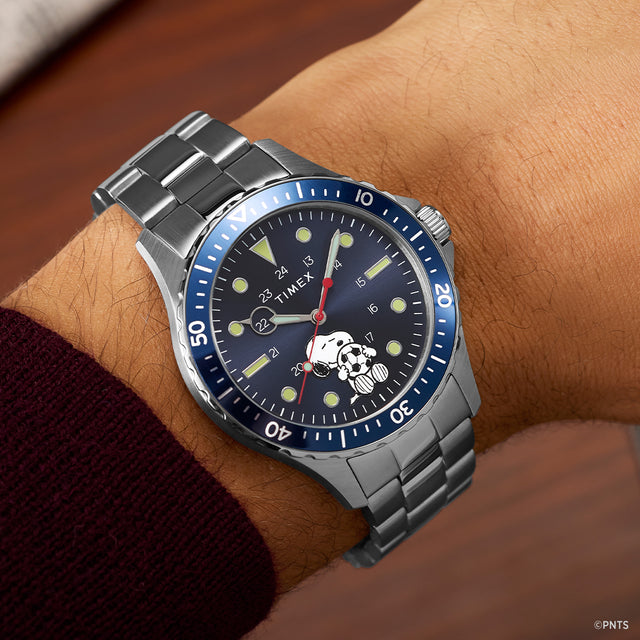 Timex Navi x Peanuts Snoopy soccer watch with blue dial worn on wrist with stainless steel bracelet