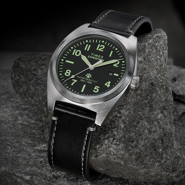 Timex Expedition Capstone watch with black dial and black leather strap on rock surface