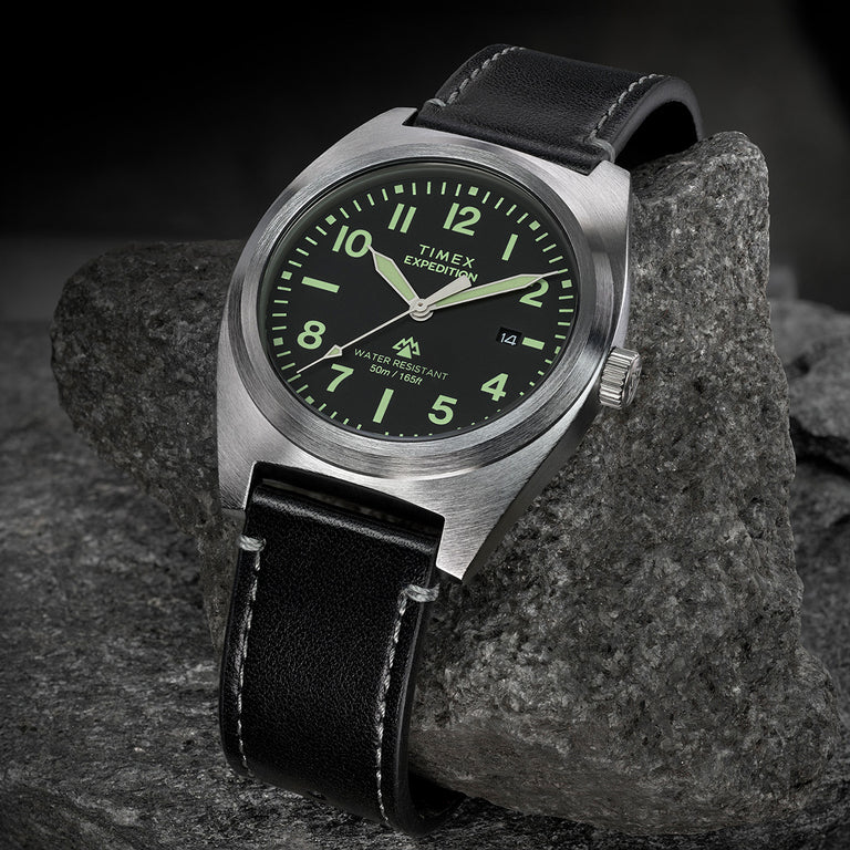 Timex Expedition Capstone watch with black dial and black leather strap on rock surface