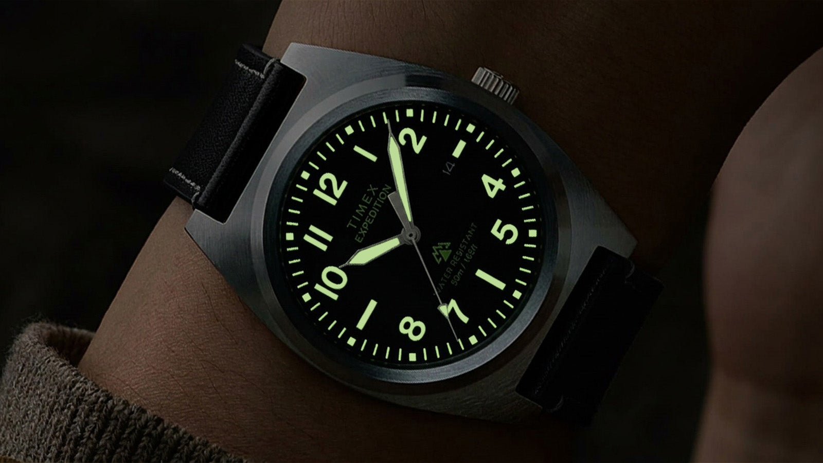 Timex Expedition Capstone watch with glowing lume markers and hands on wrist in low light