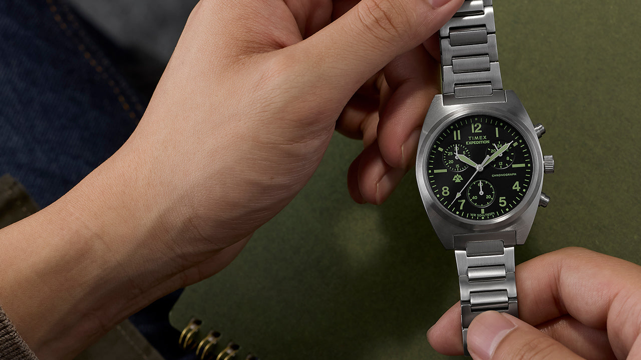 Timex Expedition Capstone Chronograph with stainless steel bracelet held in hands showing black dial