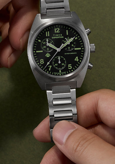Timex Expedition Capstone Chronograph with stainless steel bracelet held in hands showing black dial