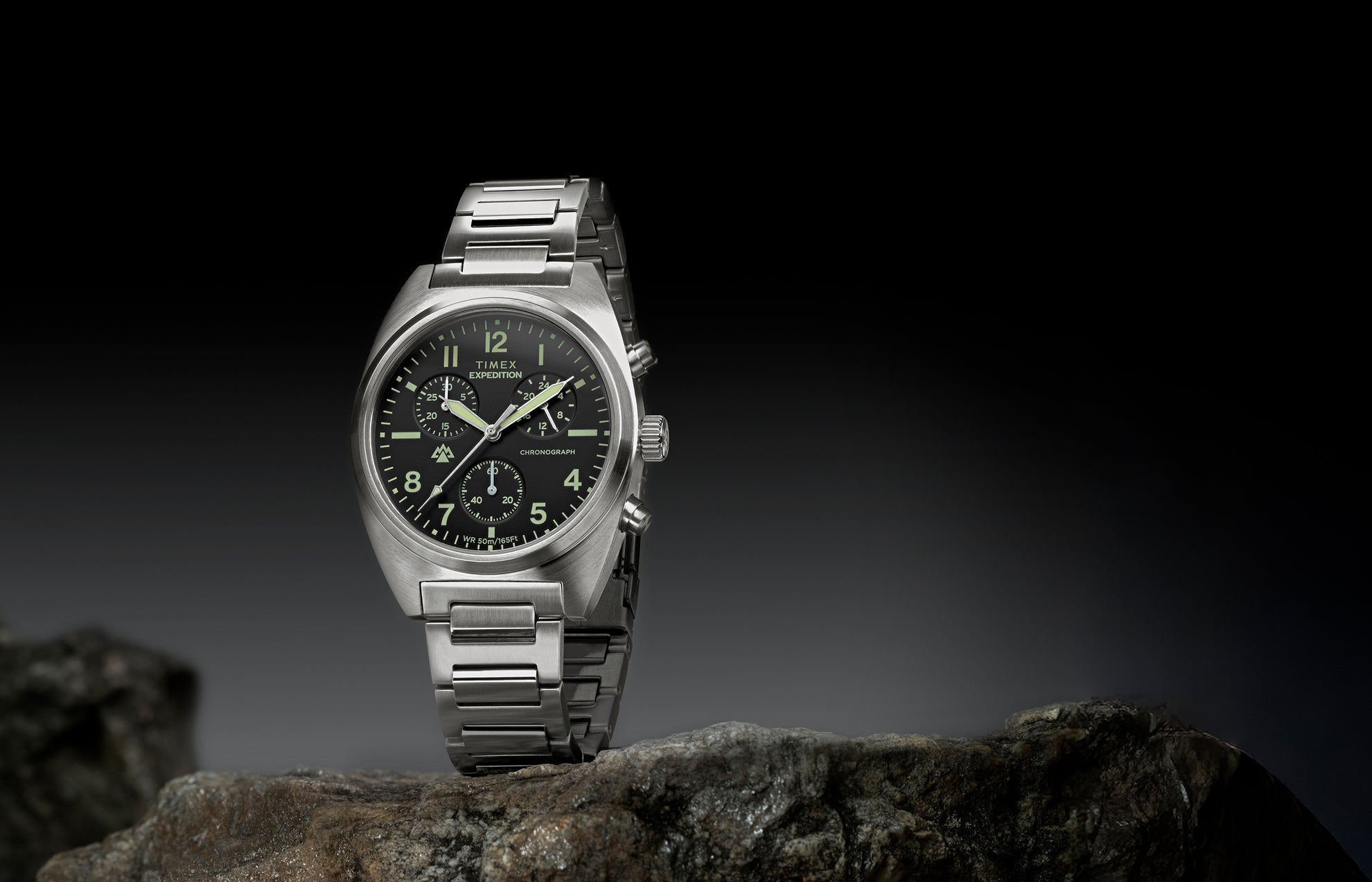 Timex Expedition Capstone Chronograph with stainless steel bracelet displayed on rocks outdoors