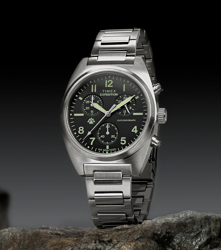 Timex Expedition Capstone Chronograph with stainless steel bracelet displayed on rocks outdoors