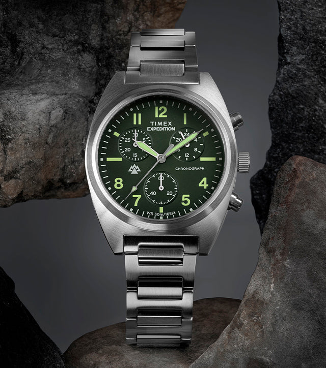 Timex Expedition Capstone Chronograph with green dial and stainless steel bracelet displayed on rocks