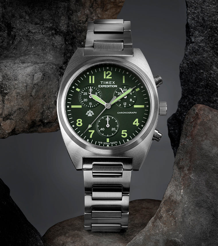 Timex Expedition Capstone Chronograph with green dial and stainless steel bracelet displayed on rocks