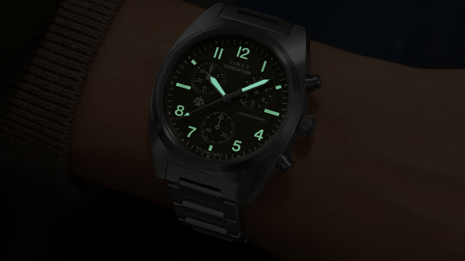 Timex Expedition Capstone Chronograph green dial illuminated with lume on wrist in dark setting