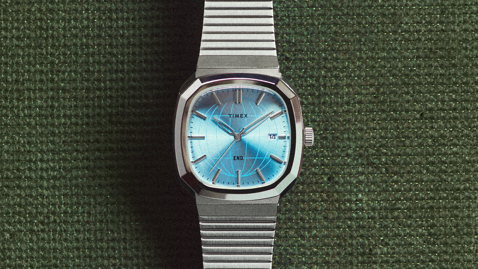 END. x Timex 1981 Reissue Inspired watch with a stainless-steel case, blue globe-pattern dial, and expansion bracelet.
