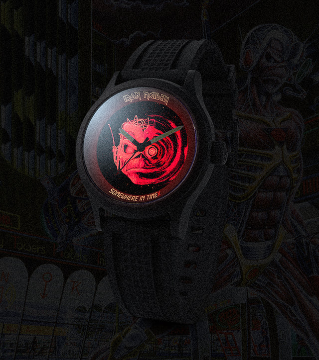 Dark promotional image of the Timex x Iron Maiden 1986 Tribute watch with a glowing red Eddie dial design set against a futuristic dystopian city backdrop.