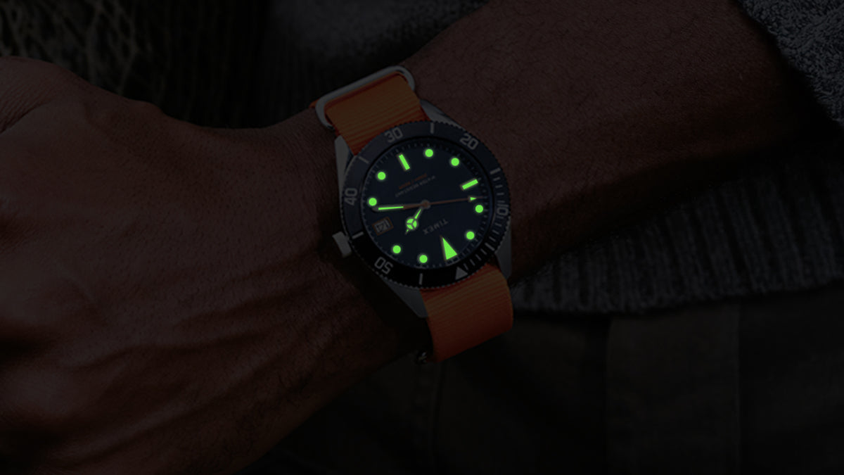 Bespoke Post x Timex Heritage 66 watch featuring luminous green hands and hour markers in the dark.