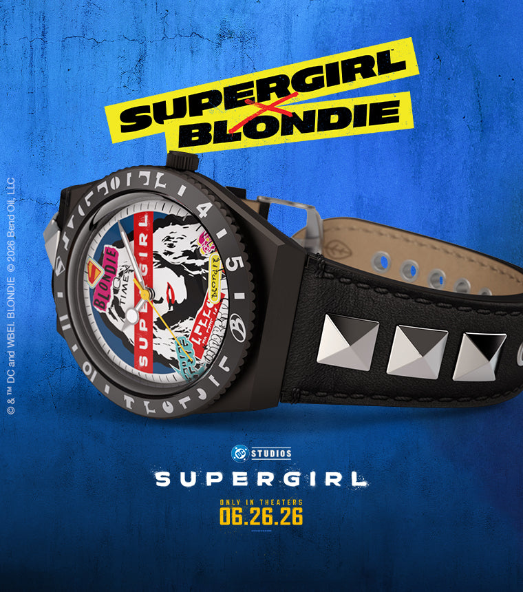 Timex x Supergirl Blondie watch with studded black leather strap and graphic Blondie-inspired dial, shown on a blue background with Supergirl movie branding.