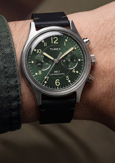 Close-up of the Timex MK1® Chronograph with a green dial and black leather strap worn on the wrist.