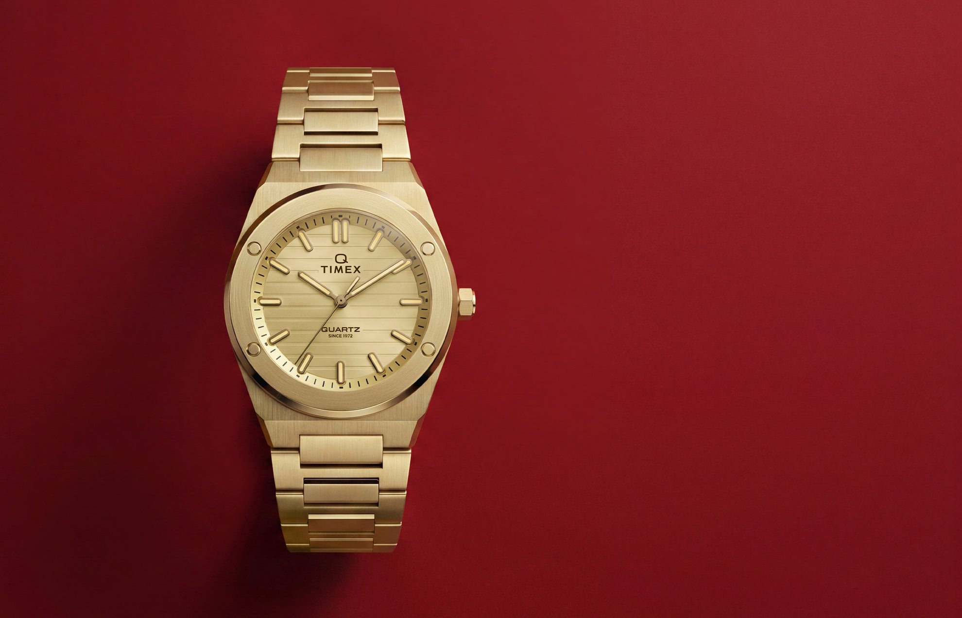 Front view of the Q Timex Marbella gold-tone stainless steel watch featuring a champagne dial and integrated bracelet.