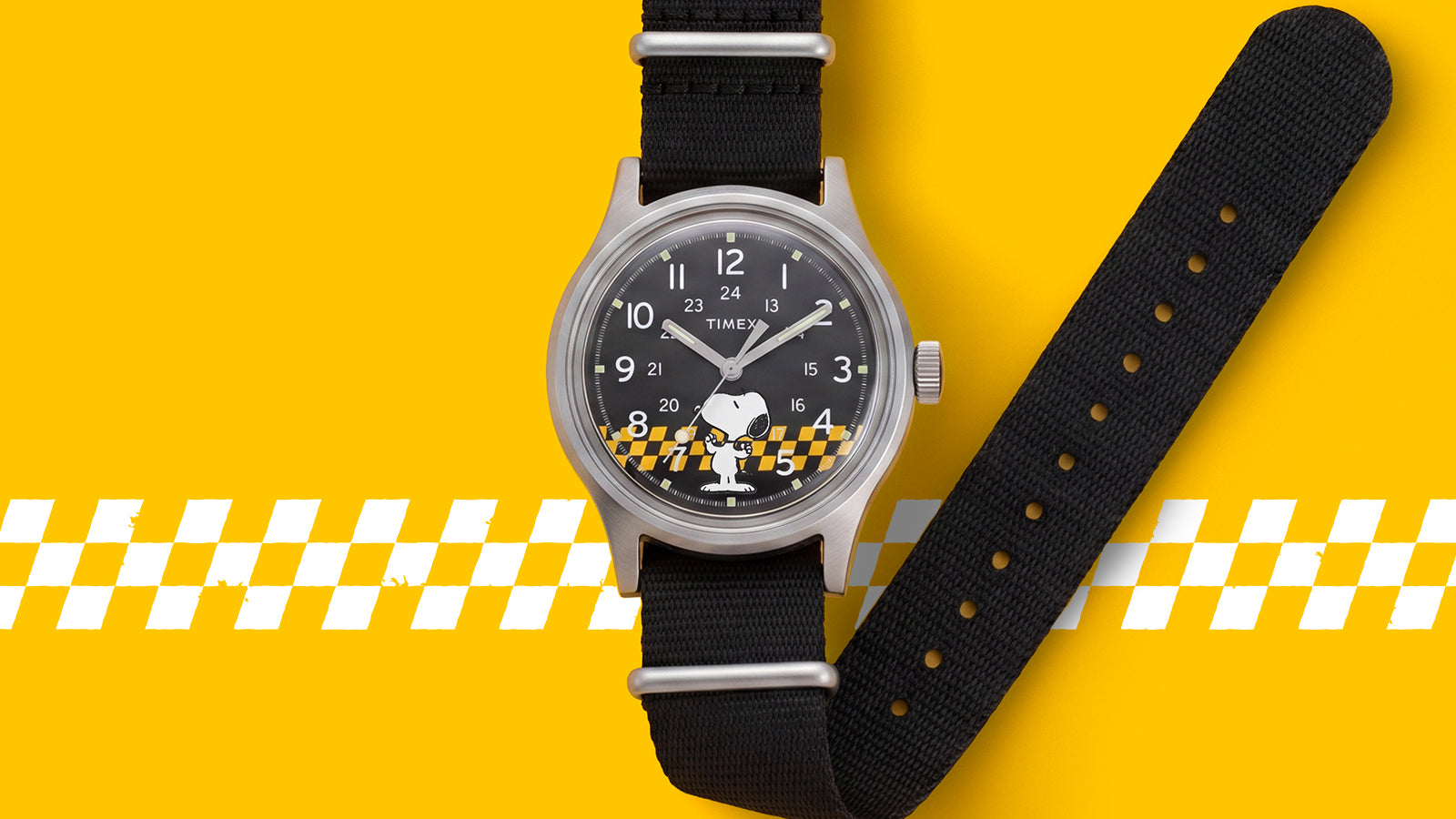 Front view of the Peanuts® x Timex MK1® featuring a black dial with Snoopy artwork, silver-tone case, and black fabric strap.