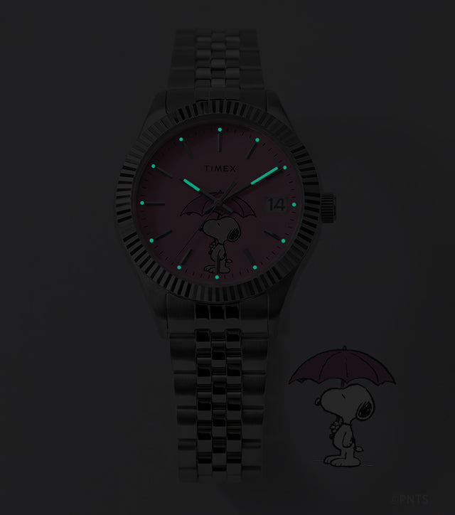 Peanuts® x Timex Legacy Snoopy Umbrella watch with INDIGLO® illumination, featuring glowing hands and hour markers against a dark background.
