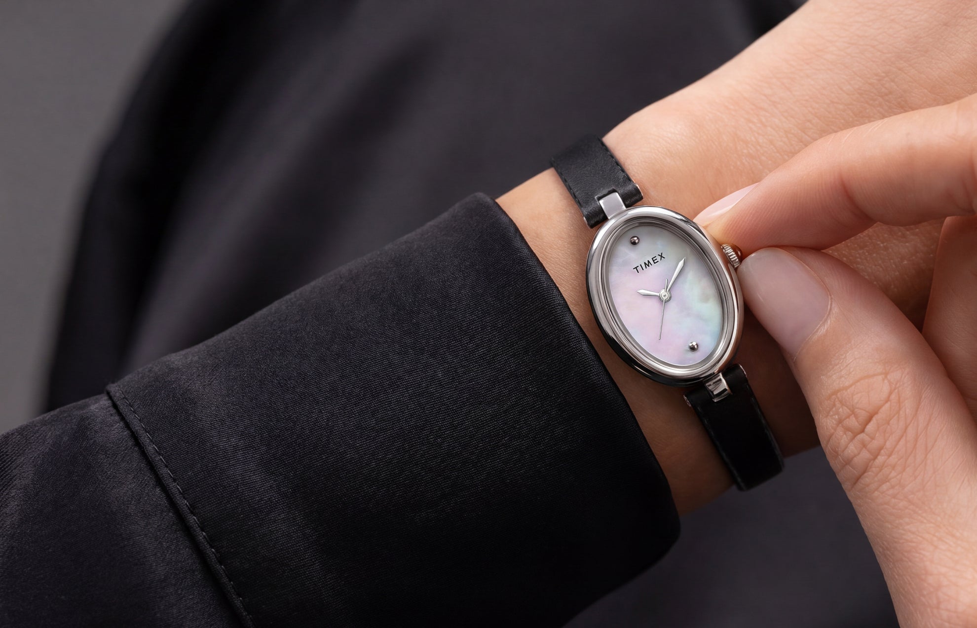 Reloj Timex Cavatina® Luxe en tono plateado, con esfera de nácar y correa de piel negra, lucido en la muñeca.