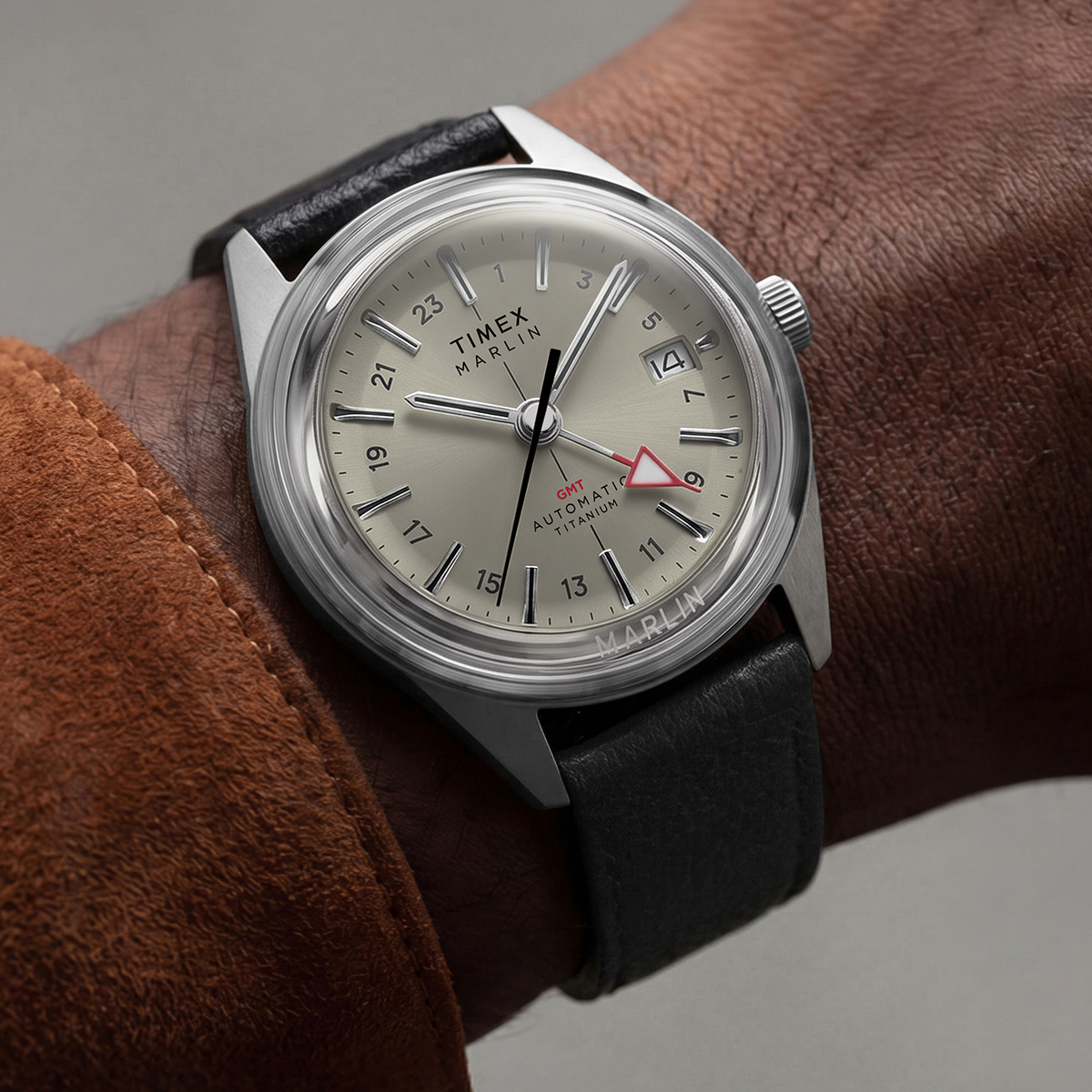 Close-up of the Marlin® Jet Titanium Automatic GMT on the wrist, featuring a cream dial, red GMT hand, date window, and black leather strap.