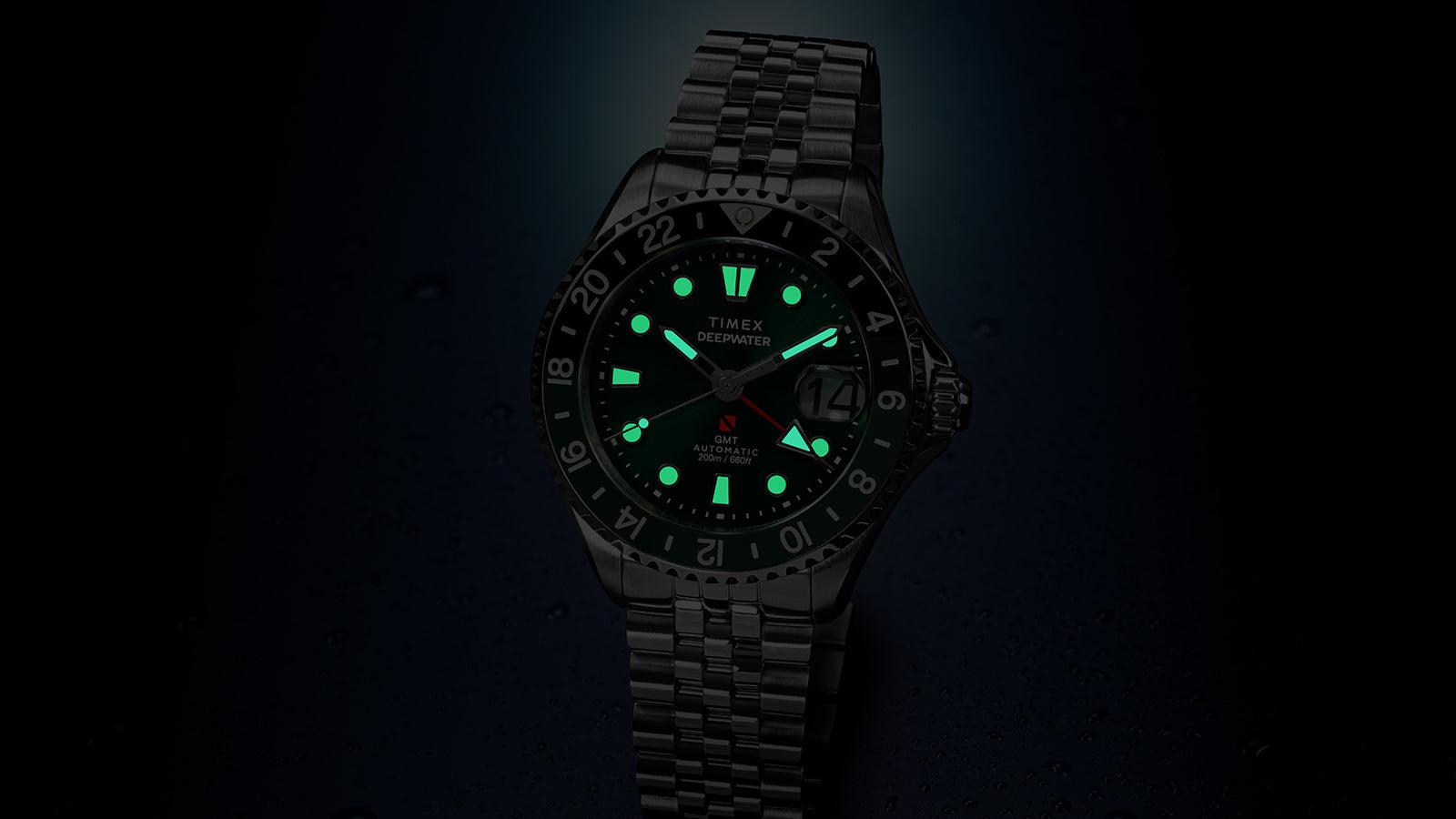 Timex Deepwater Meridian 200 Automatic GMT in low light with luminous hands and hour markers glowing brightly for enhanced nighttime readability.