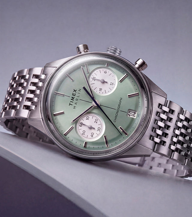 Timex Marlin® Jet Chronograph with a green dial and stainless-steel bracelet displayed on an angled surface.