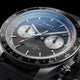 Close-up of the Timex Waterbury Heritage Chronograph featuring a black and silver panda-style dial, dual chronograph sub-dials, tachymeter bezel, and red chronograph accents.