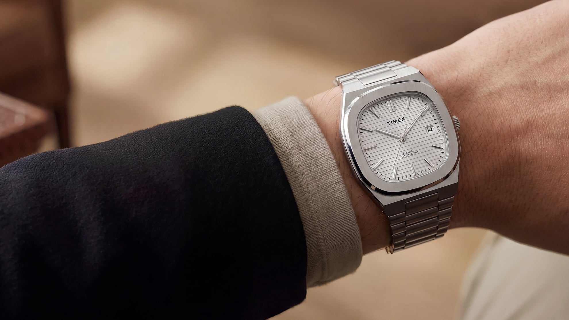 Timex Automatic E Line 38mm with a silver-tone dial and stainless-steel bracelet, shown on the wrist.