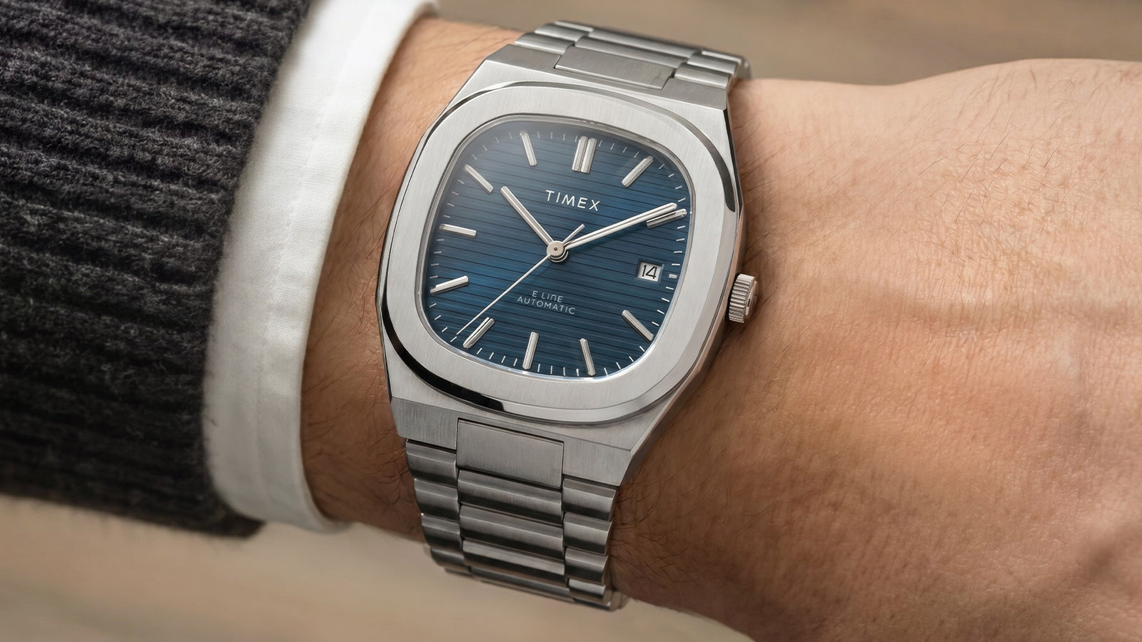 Reloj Timex® Automatic E Line de 38 mm, de acero inoxidable, con esfera azul texturizada, puesto en la muñeca.