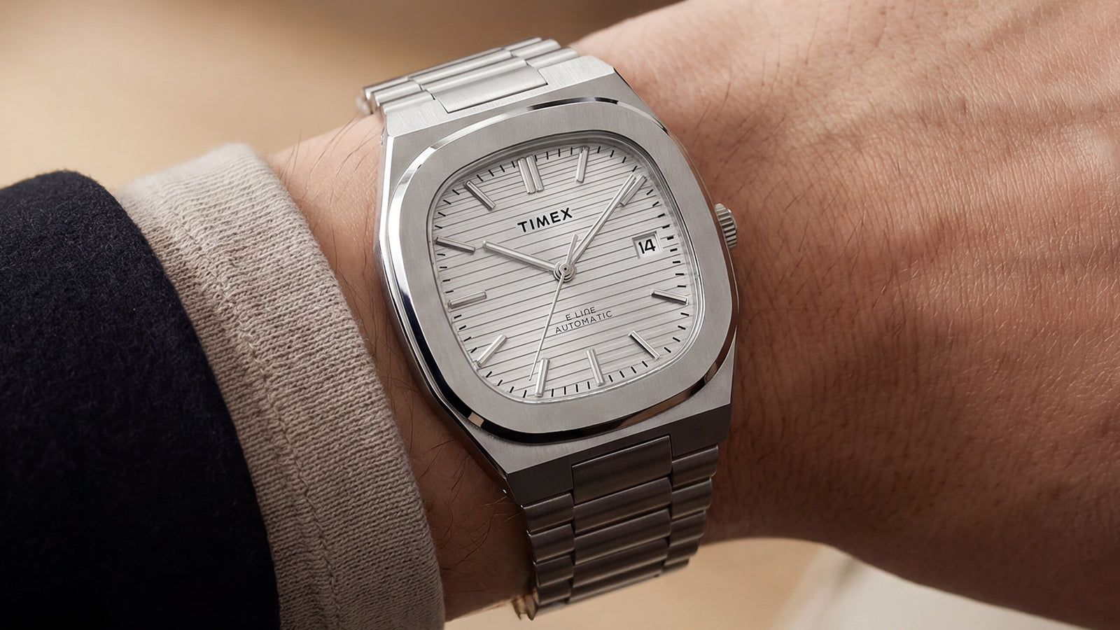 Timex Automatic E Line 38mm shown in a close-up on the wrist, highlighting its silver-tone dial and date window.