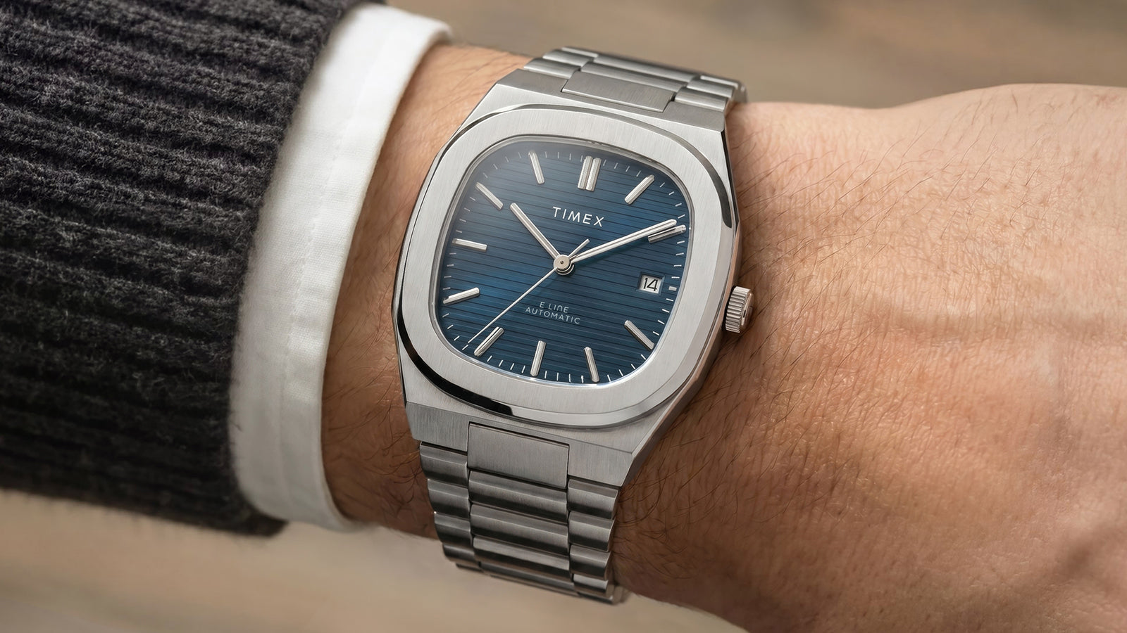 Close-up of the Timex Automatic E Line 38mm on the wrist, highlighting its textured blue dial, silver-tone markers, and date window.