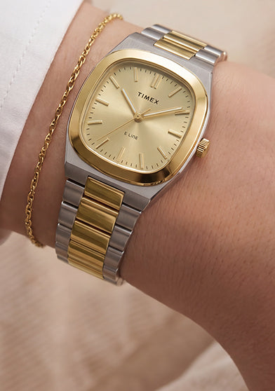 Close-up of the Timex® Quartz E Line 30mm two-tone stainless steel watch with a champagne dial worn on the wrist.
