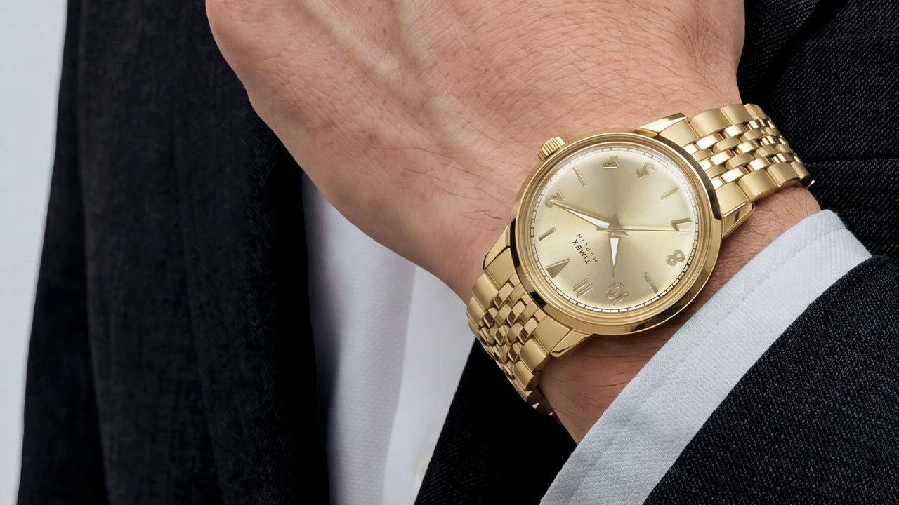 Timex Marlin Quartz with a champagne sunray dial and gold-tone stainless steel bracelet worn on the wrist.