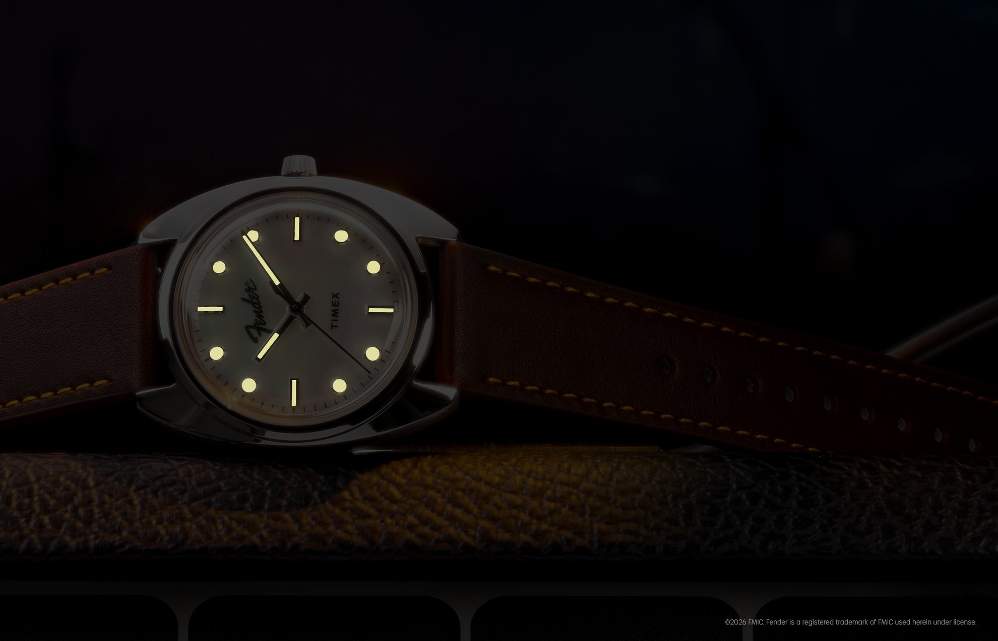 Fender x Timex watch displayed in low light with glowing hands and hour markers.