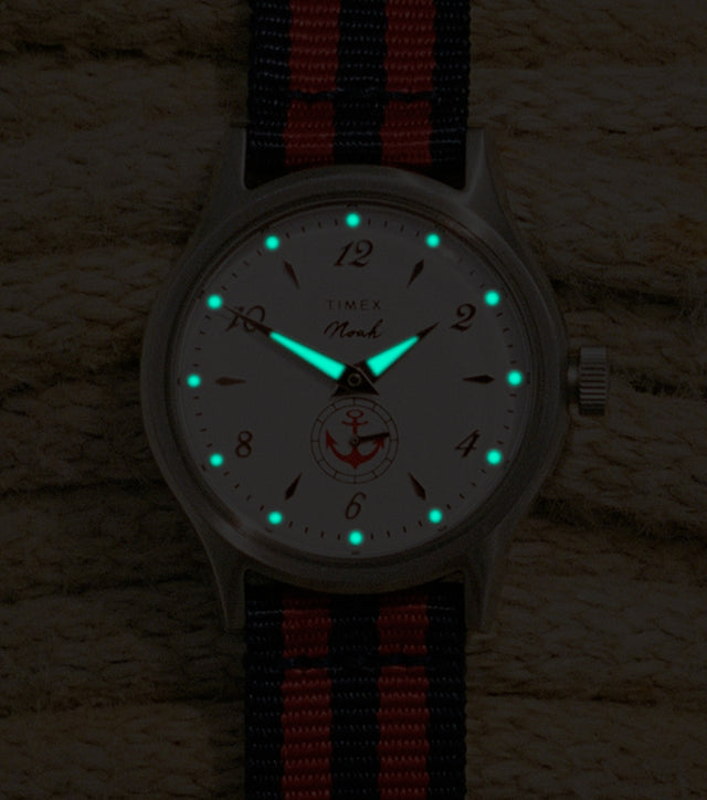 Reloj NOAH x Timex MK1 Anchor con correa de cuerda náutica, agujas y índices luminosos que brillan en la oscuridad.