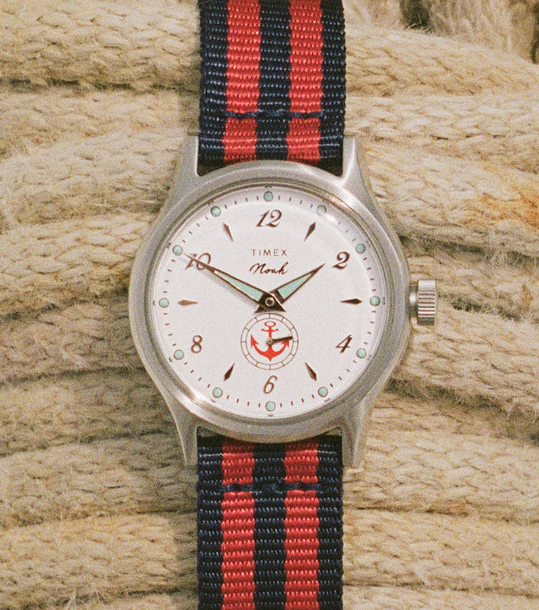 NOAH x Timex MK1 Anchor watch with a white dial and red-and-navy striped fabric strap resting on coiled nautical rope.