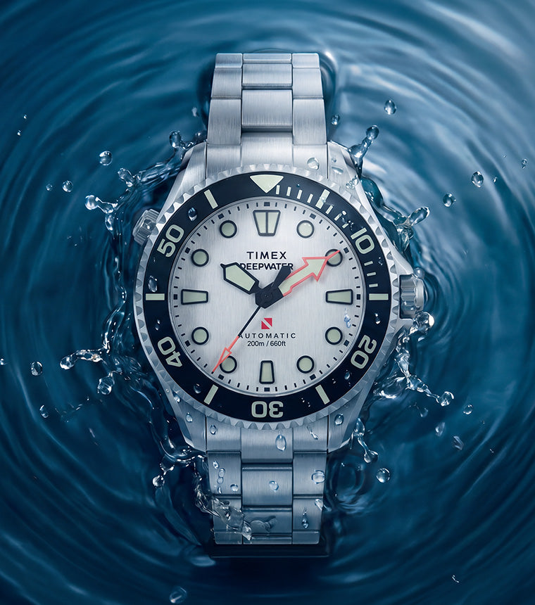 Deepwater Meridian 200 HEV Automatic with a silver-tone dial and stainless-steel bracelet surrounded by splashing blue water.