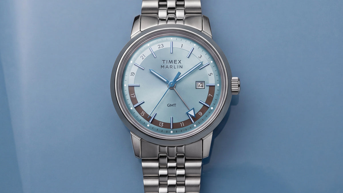 Front close-up of the Marlin® Quartz GMT featuring an icy blue dial, 24-hour scale, date window, and stainless-steel bracelet.