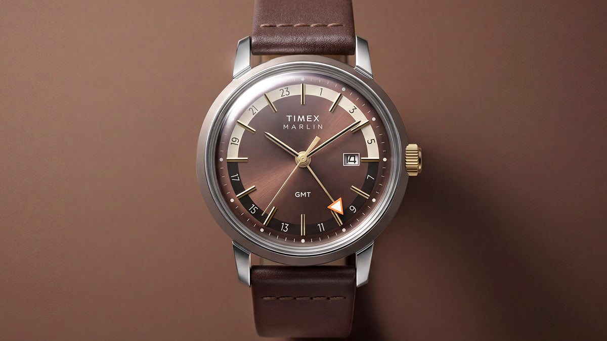 Front view of the Marlin® Quartz GMT with a brown dial, gold-tone accents, orange GMT hand, and leather strap.