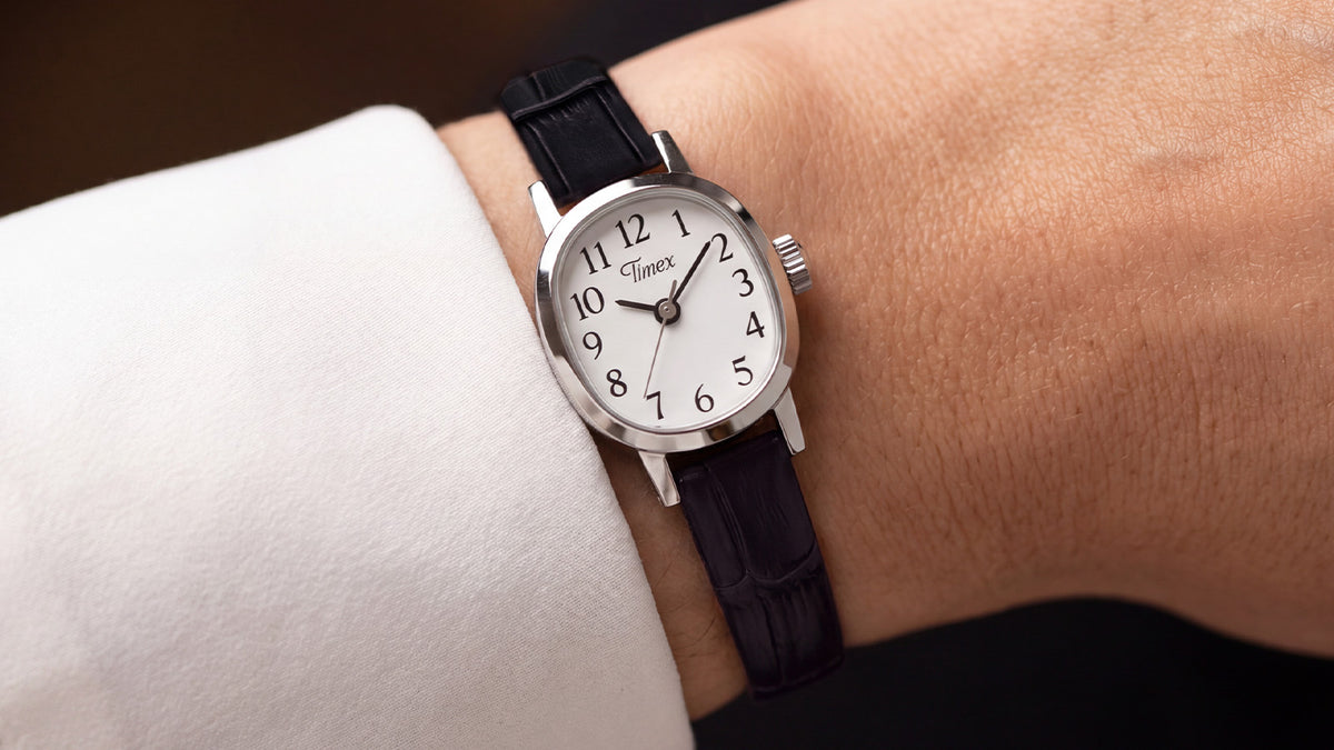 Close-up of the Cavatina® Mini with a black leather strap worn on a wrist beneath a white sleeve.